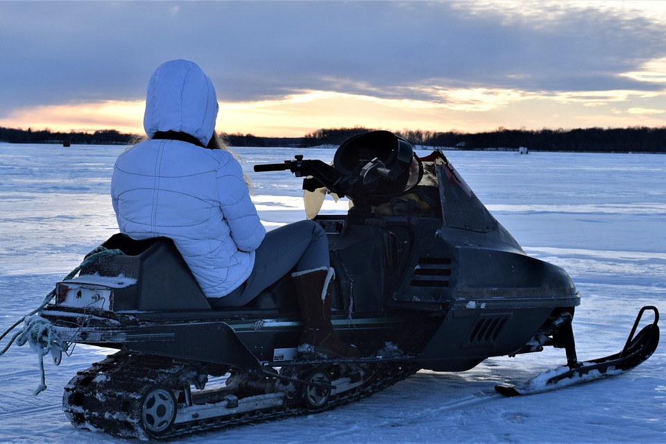 girl on snowmobile on ice