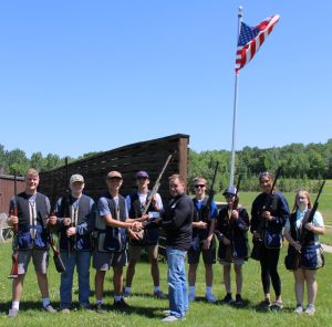 Jeff Anderson, the owner of Pine Point Resort, presents a $1,000 donation to members of the WHAN trapshooting team.