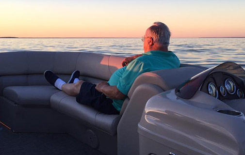 Man watching the sunset from a boat on Leech Lake