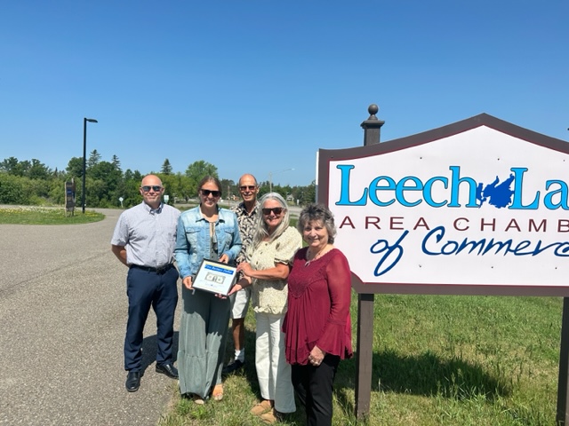 People in front of Leech Lake Chamber of commerce sign